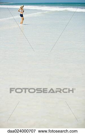 Young woman jogging in surf, in mid-distance View Large Photo Image Stock Photo - Young woman jogging in surf, in mid-distance. Fotosearch