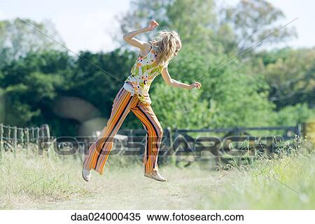 Young woman jumping in rural field, side view View Large Photo Image Stock Photography - Young woman jumping in rural field, side view. Fotosearch