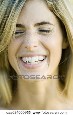 Stock Photography - Young woman laughing with eyes closed, portrait, close-up. Fotosearch