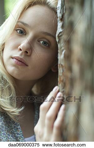 Young woman leaning against tree, portrait View Large Photo Image Stock Photography - Young woman leaning against tree, portrait. Fotosearch