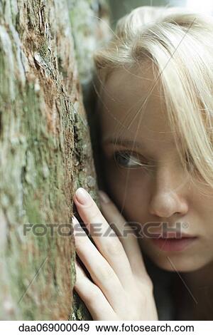 Young woman leaning against tree trunk View Large Photo Image Stock Photo - Young woman leaning against tree trunk. Fotosearch