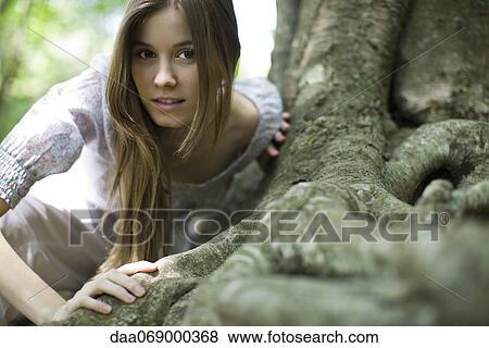 Young woman leaning on roots of tree View Large Photo Image Stock Photo - Young woman leaning on roots of tree. Fotosearch