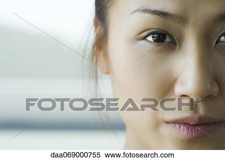 Young woman looking at camera, cropped portrait View Large Photo Image Stock Photography - Young woman looking at camera, cropped portrait. Fotosearch