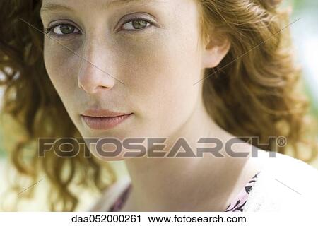 Stock Image - Young woman looking at camera, portrait. Fotosearch