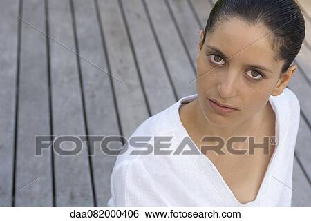 Stock Photograph - Young woman looking at camera, portrait. Fotosearch