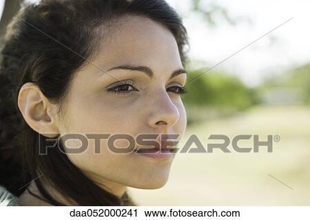 Stock Image - Young woman looking away in thought. Fotosearch