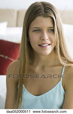 Stock Image - Young woman looking away, portrait. Fotosearch