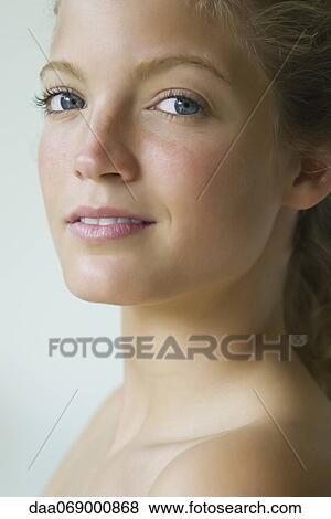 Young woman looking over shoulder at camera, portrait View Large Photo Image Stock Photo - Young woman looking over shoulder at camera, portrait. Fotosearch