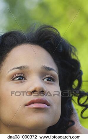 Young woman looking up in thought, portrait View Large Photo Image Stock Image - Young woman looking up in thought, portrait. Fotosearch