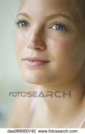 Stock Image - Young woman looking up, portrait. Fotosearch