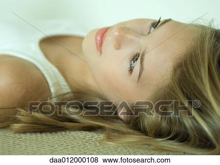 Stock Photo - Young woman lying on back, close-up of head and shoulders. Fotosearch