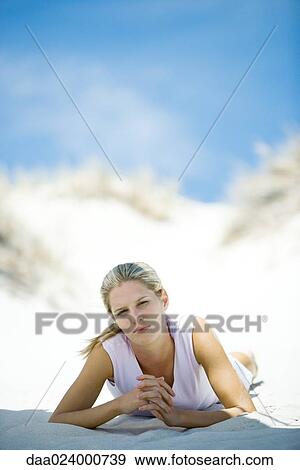 Stock Photo - Young woman lying on beach. Fotosearch