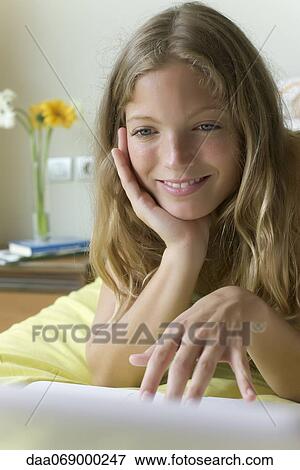 Young woman lying on stomach in bed, using laptop computer View Large Photo Image Stock Photo - Young woman lying on stomach in bed, using laptop computer. Fotosearch