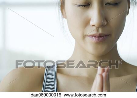 Stock Photograph - Young woman meditating in prayer position. Fotosearch