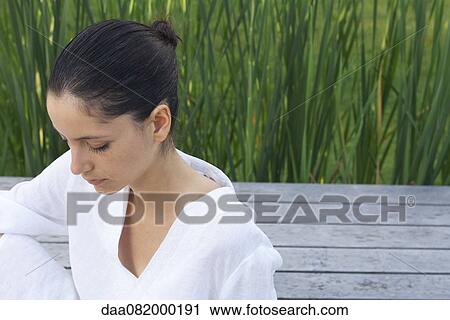 Stock Image - Young woman meditating outdoors. Fotosearch