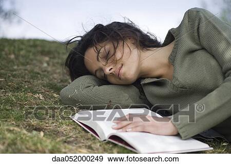 Young woman napping on ground with book View Large Photo Image Stock Photo - Young woman napping on ground with book. Fotosearch