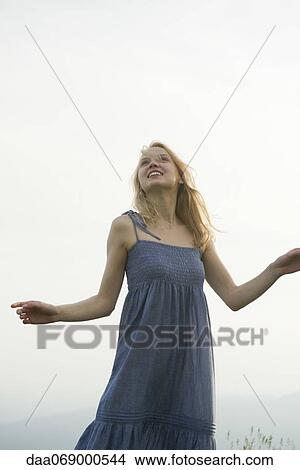 Young woman outdoors, looking up View Large Photo Image Picture - Young woman outdoors, looking up. Fotosearch