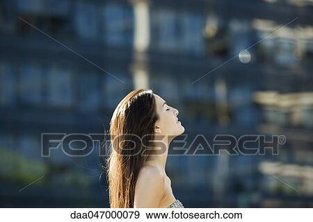 Young woman outdoors on sunny day, head back, eyes closed View Large Photo Image Stock Photo - Young woman outdoors on sunny day, head back, eyes closed. Fotosearch