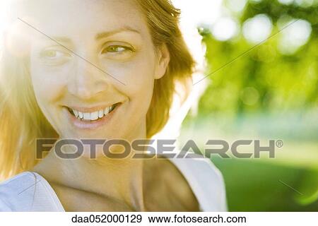 Stock Photo - Young woman outdoors on sunny day, portrait. Fotosearch