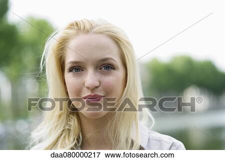 Stock Photo - Young woman outdoors, portrait. Fotosearch