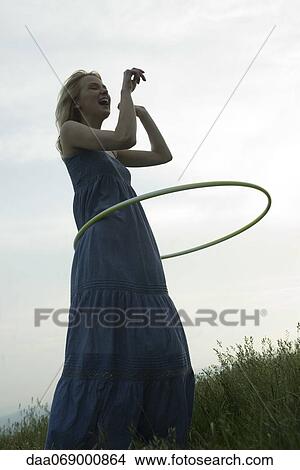 Young woman playing with plastic hoop outdoors View Large Photo Image Picture - Young woman playing with plastic hoop outdoors. Fotosearch