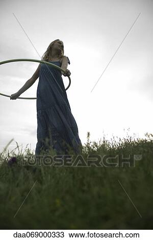 Young woman playing with plastic hoop outdoors View Large Photo Image Stock Image - Young woman playing with plastic hoop outdoors. Fotosearch