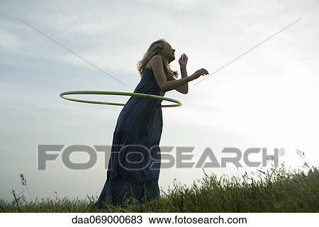 Young woman playing with plastic hoop outdoors View Large Photo Image Stock Image - Young woman playing with plastic hoop outdoors. Fotosearch