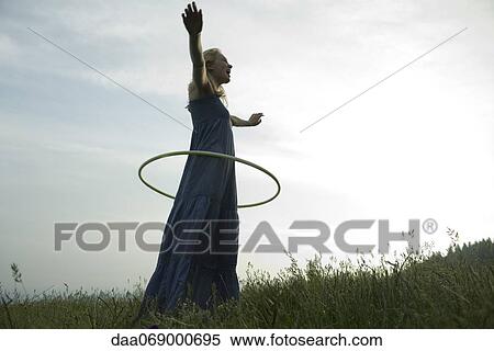 Young woman playing with plastic hoop outdoors View Large Photo Image Stock Photography - Young woman playing with plastic hoop outdoors. Fotosearch