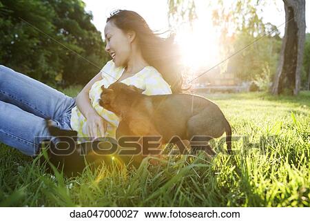 Young woman playing with two puppies outdoors View Large Photo Image Stock Photo - Young woman playing with two puppies outdoors. Fotosearch