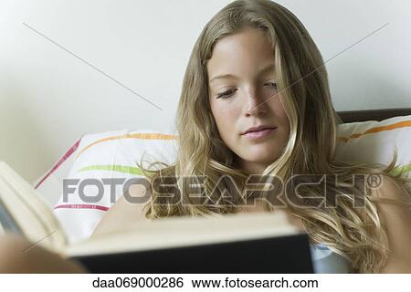 Young woman reading book View Large Photo Image Stock Photograph - Young woman reading book. Fotosearch