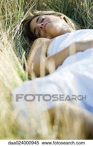 Young woman reclining in tall grass with eyes closed View Large Photo Image Stock Photography - Young woman reclining in tall grass with eyes closed. Fotosearch