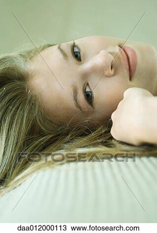 Young woman reclining, smiling at camera, close-up of face View Large Photo Image Stock Image - Young woman reclining, smiling at camera, close-up of face. Fotosearch