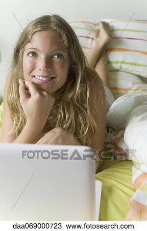 Young woman relaxing in bed with laptop computer View Large Photo Image Stock Image - Young woman relaxing in bed with laptop computer. Fotosearch