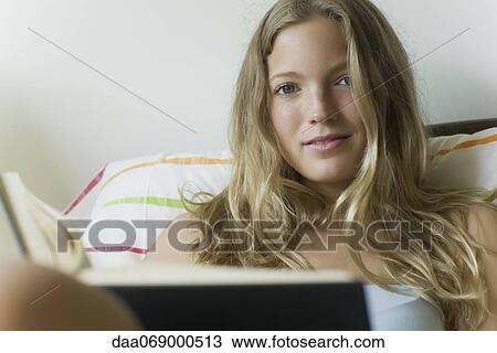 Young woman relaxing with book, portrait View Large Photo Image Stock Image - Young woman relaxing with book, portrait. Fotosearch