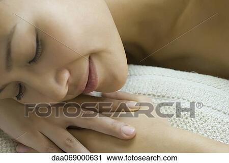 Young woman resting head on arms with eyes closed View Large Photo Image Stock Image - Young woman resting head on arms with eyes closed. Fotosearch