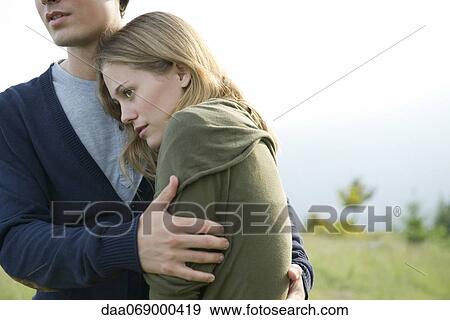 Stock Photo - Young woman resting head on boyfriend's shoulder. Fotosearch