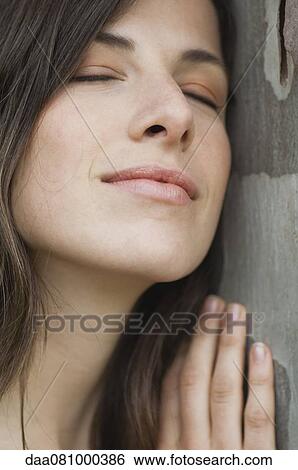 Young woman resting head on wall with eyes closed View Large Photo Image Stock Photograph - Young woman resting head on wall with eyes closed. Fotosearch