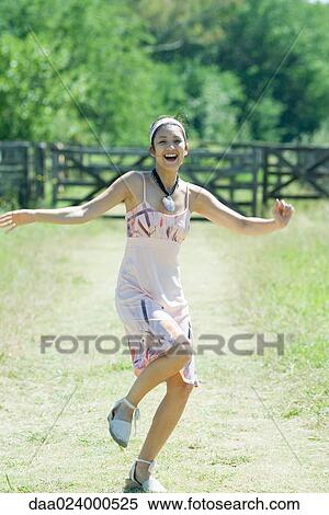 Young woman running along rural path, smiling at camera View Large Photo Image Stock Photography - Young woman running along rural path, smiling at camera. Fotosearch