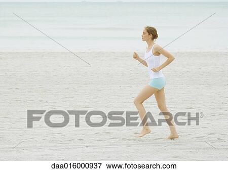 Stock Photo - Young woman running on beach. Fotosearch