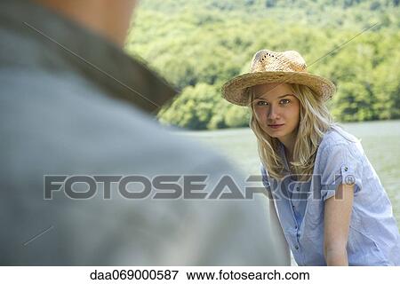 Young woman sitting by lake View Large Photo Image Stock Photo - Young woman sitting by lake. Fotosearch