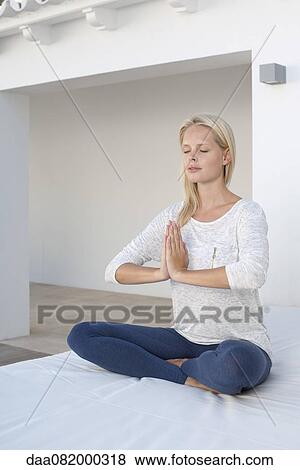 Young woman sitting in prayer positon, eyes closed View Large Photo Image Stock Photo - Young woman sitting in prayer positon, eyes closed. Fotosearch