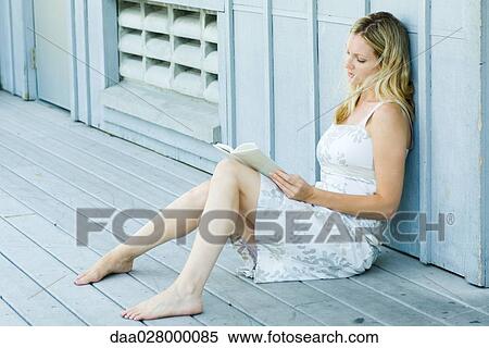 Young woman sitting on deck, reading book View Large Photo Image Stock Photography - Young woman sitting on deck, reading book. Fotosearch