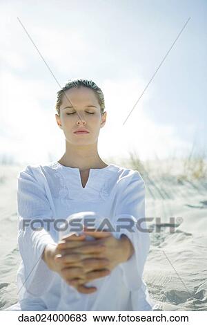 Young woman sitting on dune with eyes closed View Large Photo Image Stock Image - Young woman sitting on dune with eyes closed. Fotosearch