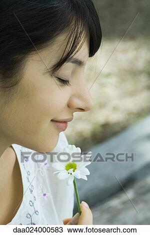 Young woman smelling flower with eyes closed, profile View Large Photo Image Stock Image - Young woman smelling flower with eyes closed, profile. Fotosearch