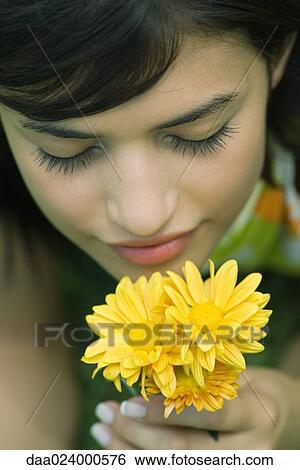 Young woman smelling flowers, eyes closed, high angle view, cropped View Large Photo Image Stock Photograph - Young woman smelling flowers, eyes closed, high angle view, cropped. Fotosearch