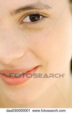 Stock Image - Young woman smiling at camera, cropped, portrait. Fotosearch