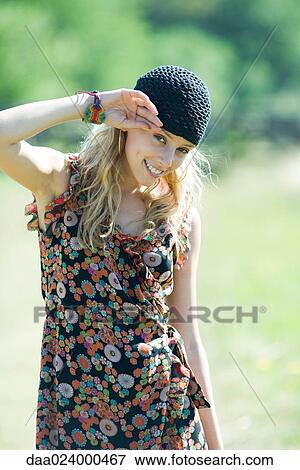 Stock Photo - Young woman smiling at camera outdoors, portrait. Fotosearch