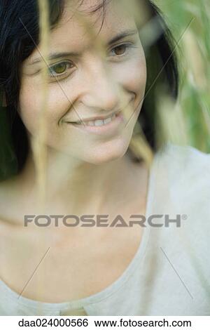 Young woman smiling, looking away, portrait View Large Photo Image Stock Photograph - Young woman smiling, looking away, portrait. Fotosearch