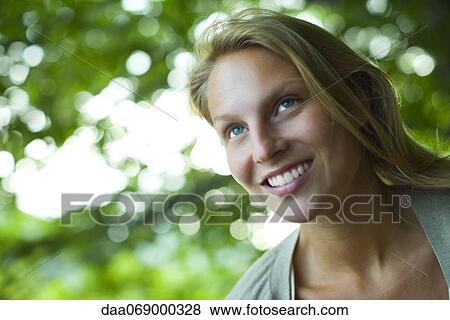 Young woman smiling, looking up, portrait View Large Photo Image Stock Photo - Young woman smiling, looking up, portrait. Fotosearch