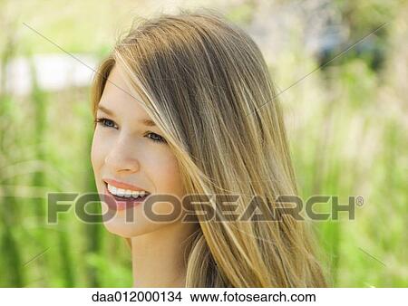 Picture - Young woman smiling outdoors, portrait. Fotosearch